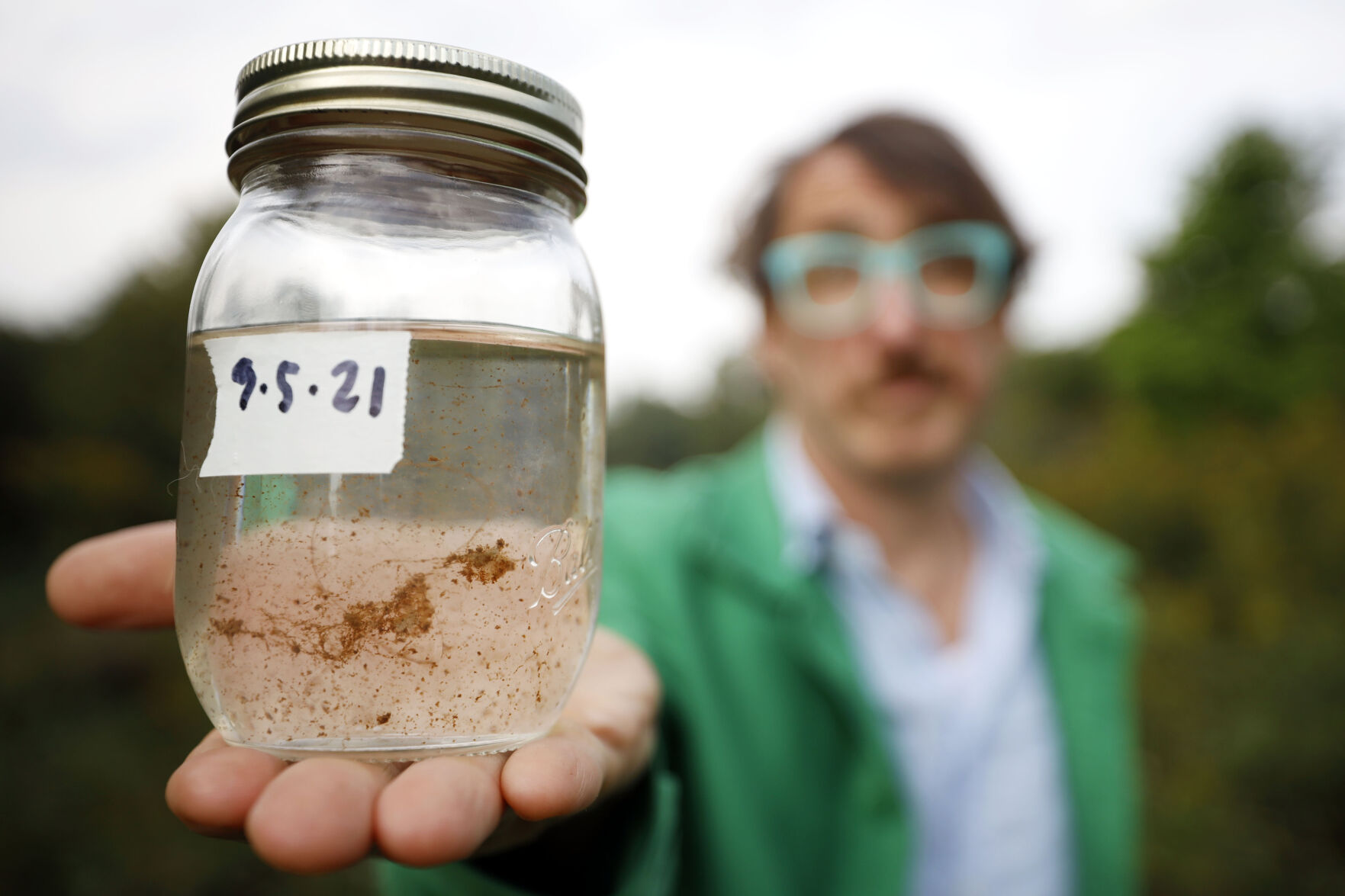 Reed Anderson holding jar of dirty tap water